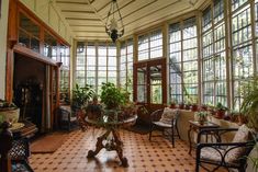 the sun room is filled with potted plants