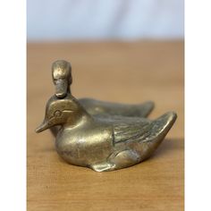 a metal duck sitting on top of a wooden table