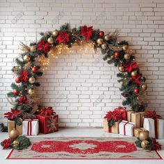 an arch decorated with christmas decorations and presents in front of a white brick wall, surrounded by red and gold poinsettis