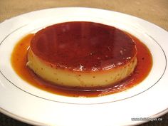 a plate topped with a dessert covered in sauce on top of a brown tablecloth