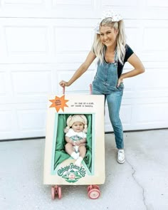 a woman standing next to a cart with a baby in it and an orange star on top