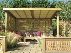 a wooden bench sitting under a pergoline covered gazebo in the middle of a garden