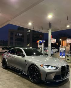 a silver sports car parked at a gas station