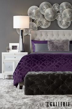 a bedroom with a bed, dresser and mirror above the headboard is decorated in silver and purple