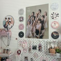 there are many pictures on the wall above the shelves and in front of them is a shelf with various items