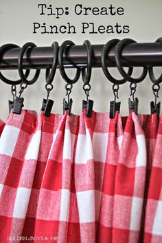 red and white checkered curtains with black metal hooks hanging from the curtain rod in front of