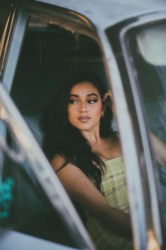 a woman sitting in the driver's seat of a car