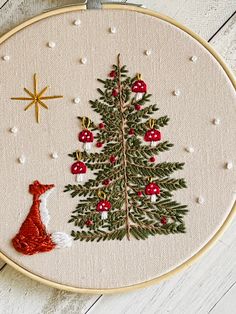 a cross stitch christmas tree with a red fox