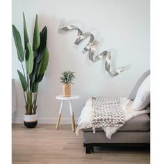 a living room filled with furniture and a large metal wall hanging over the top of a couch