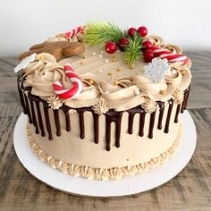 a decorated christmas cake sitting on top of a white plate next to a wooden table