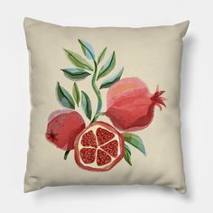 a pillow with pomegranates and leaves on it