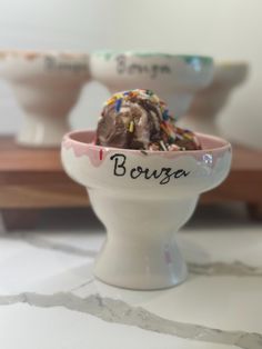 two bowls filled with ice cream and sprinkles on top of a table