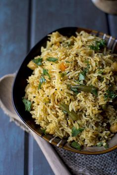 a bowl filled with rice and vegetables on top of a table