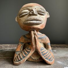 a small statue sitting on top of a wooden table