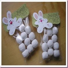 two bags filled with white marshmallows on top of a wooden table next to each other