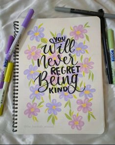 a notebook with the words you will never forget being kind written on it next to markers and pens