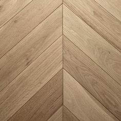 an image of wood flooring that looks like herringbones or chevroned boards