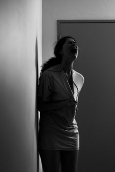 black and white photograph of a woman standing in front of a door