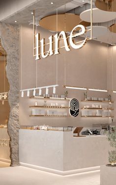 the interior of a restaurant with white walls and hanging lights above it, along with shelves filled with food