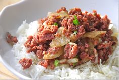 a white bowl filled with rice and meat