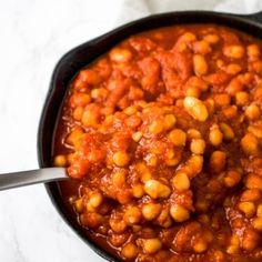 a pot filled with beans and sauce on top of a table