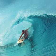 a man riding a wave on top of a surfboard in the middle of the ocean