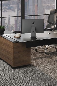 an office desk with two computers on it in front of large windows overlooking the city