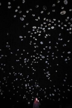 a person standing in the dark with lots of bubbles