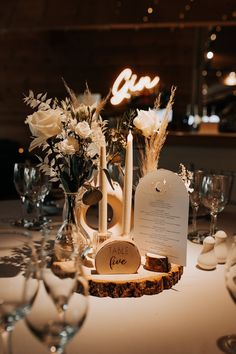 the table is set with candles, flowers and menus for an elegant wedding reception