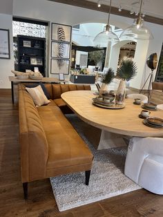 a living room filled with furniture next to a dining room table and couches on top of a hard wood floor