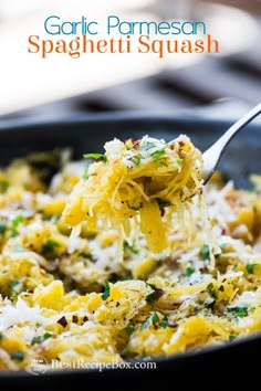 a spoon full of pasta with parmesan cheese and herbs on it, in a skillet