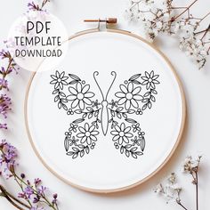 a cross stitch butterfly with flowers on it's wings is featured in the hoop