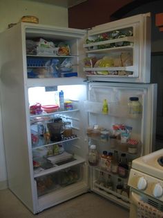 an open refrigerator with its door wide open and full of food in the fridge is shown