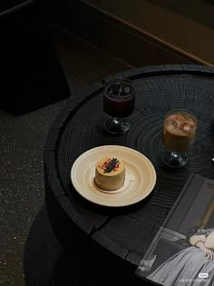 there is a cake on the table with two drinks next to it and an album