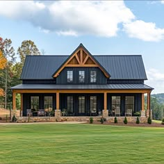 a large house with a metal roof in the middle of a grassy area next to trees