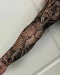 a man's arm with tattoos on it and an image of the crucifix