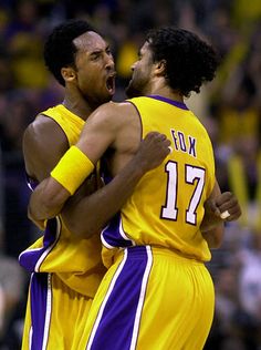 two basketball players hugging each other on the court