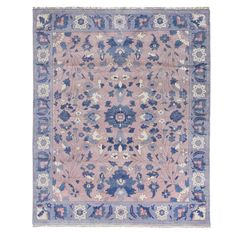 an antique rug with blue and pink flowers on the center, in front of a white background