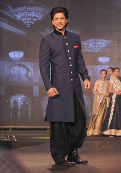 a man standing on a runway in a blue suit