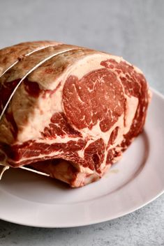 a piece of raw meat on a plate with some wire wrapped around the steaks