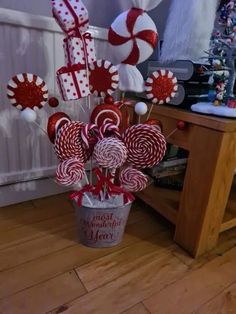 some lollipops and candy canes are in a bucket on the floor