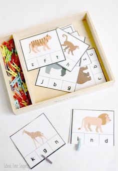 a tray filled with different types of animals and letters on top of a white table