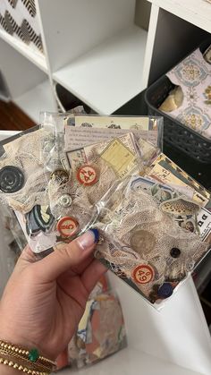 a person holding some type of money in their hand with other items on the table behind them