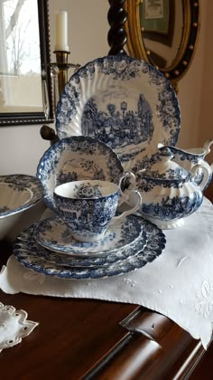 a blue and white china set on top of a wooden table