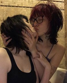 two women are kissing each other in the bathroom