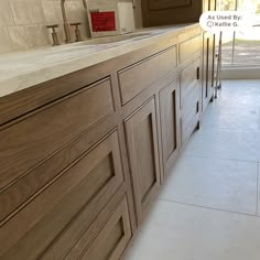 a kitchen with wooden cabinets and tile flooring