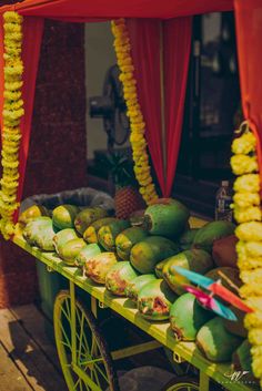 a cart filled with lots of fruit sitting on top of a wooden floor next to a building