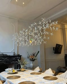 a chandelier hanging from the ceiling in a room with white walls and furniture