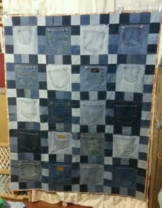 a blue and black patchwork quilt hanging on a wall