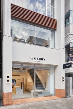 an empty store front with stairs leading up to the second floor and another building in the background